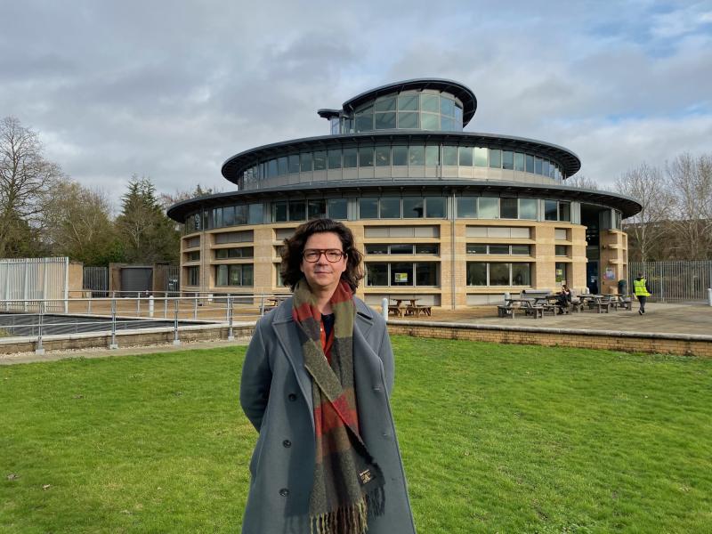 Vangelis Danopoulos standing in front of the University of Cambridge maths department