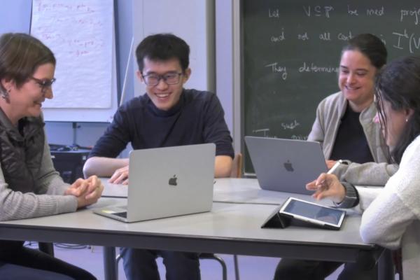 four researchers sitting around a table, laughing