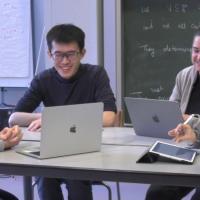 four researchers sitting around a table, laughing
