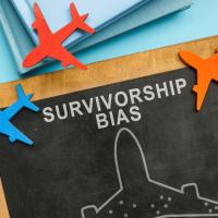 Chalkboard saying Survivorship bias, surrounded by little planes
